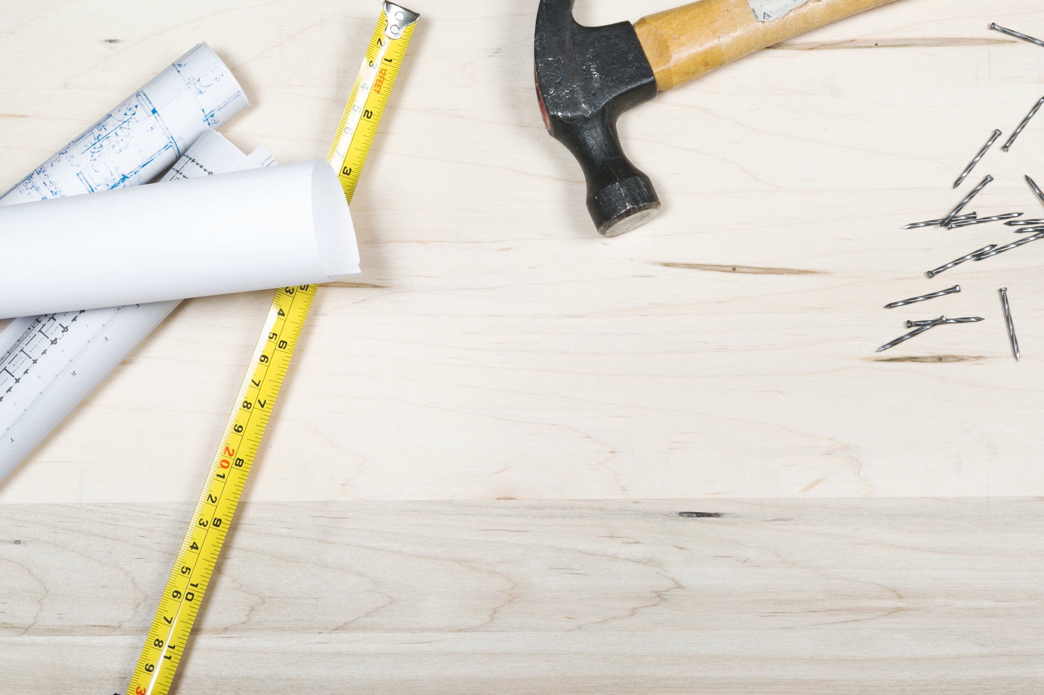 flat lay blue prints tape measure hammer and nails